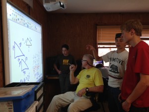 Teacher Nick and the boys looking at Smart Board at our Boys Boarding School